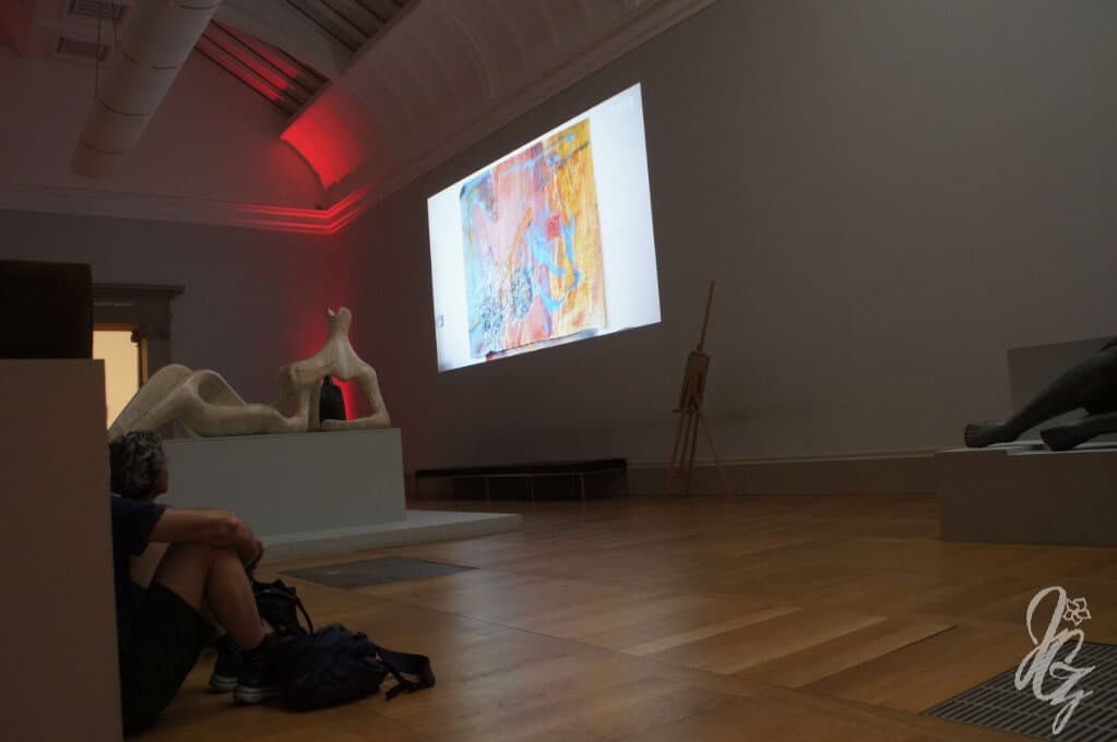 People sitting on the floor at the Tate Britain to watch a documentary