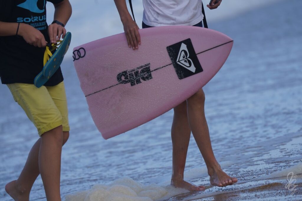 Stephanie Gilmore's broken surf board being picked up by a boy during the Roxy Pro 2019