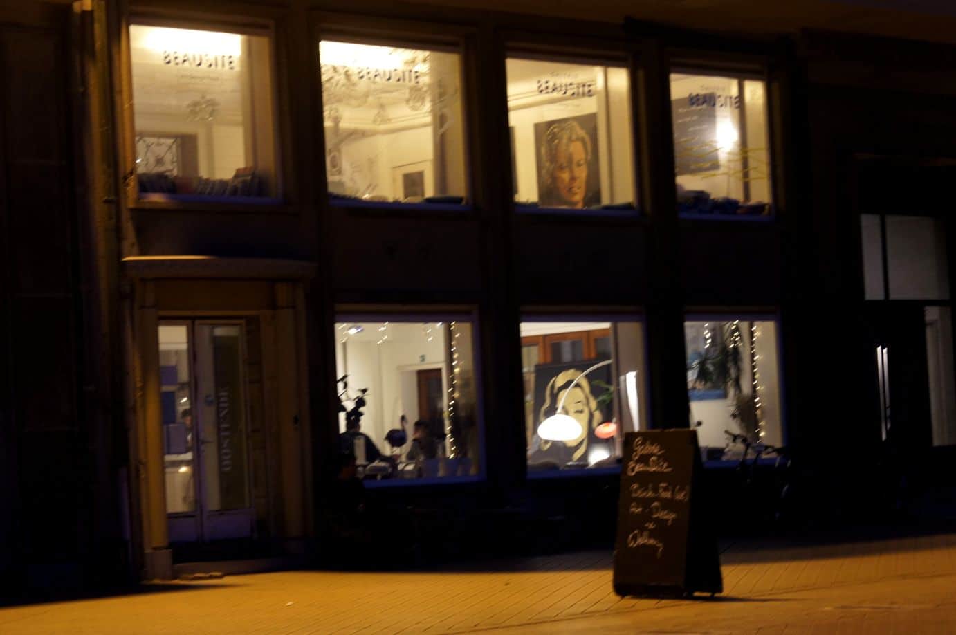 Windows to a coffee shop at the beach promenade in Ostend at blue hour
