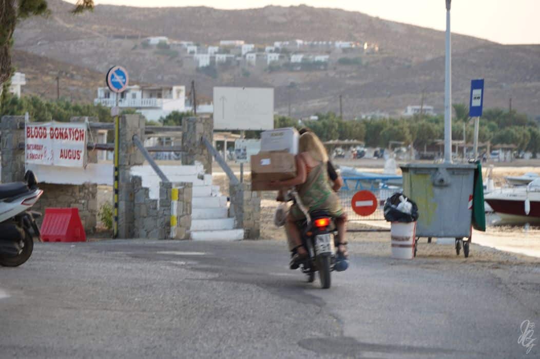 Couple on a motorcycle transporting boxes in Serifos