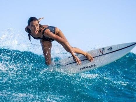 Surfer on a board by Nomads Surfing