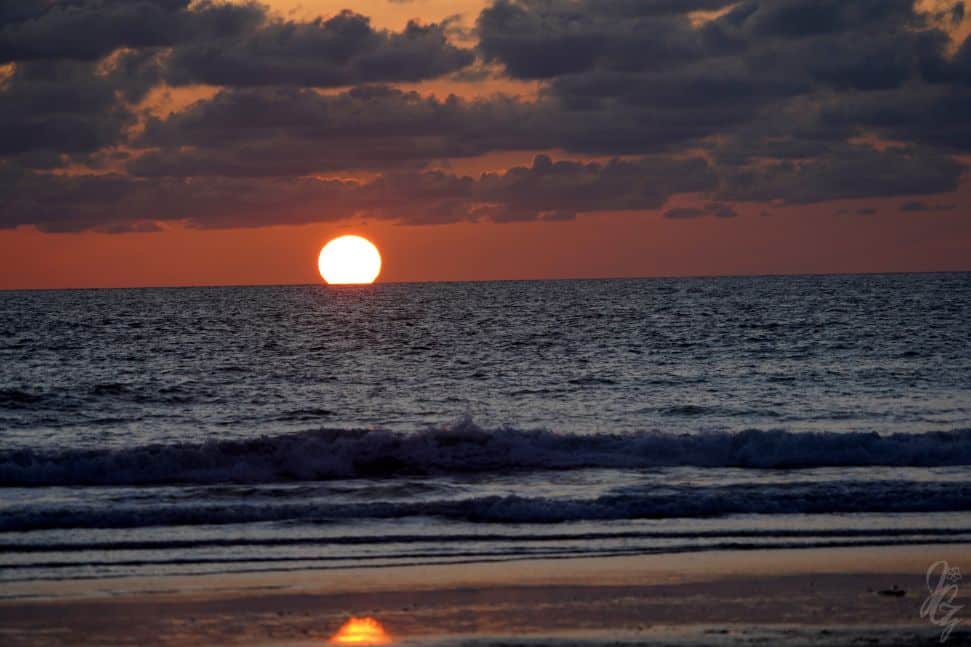 The sun turning into a red ball over the sea in El Palmar