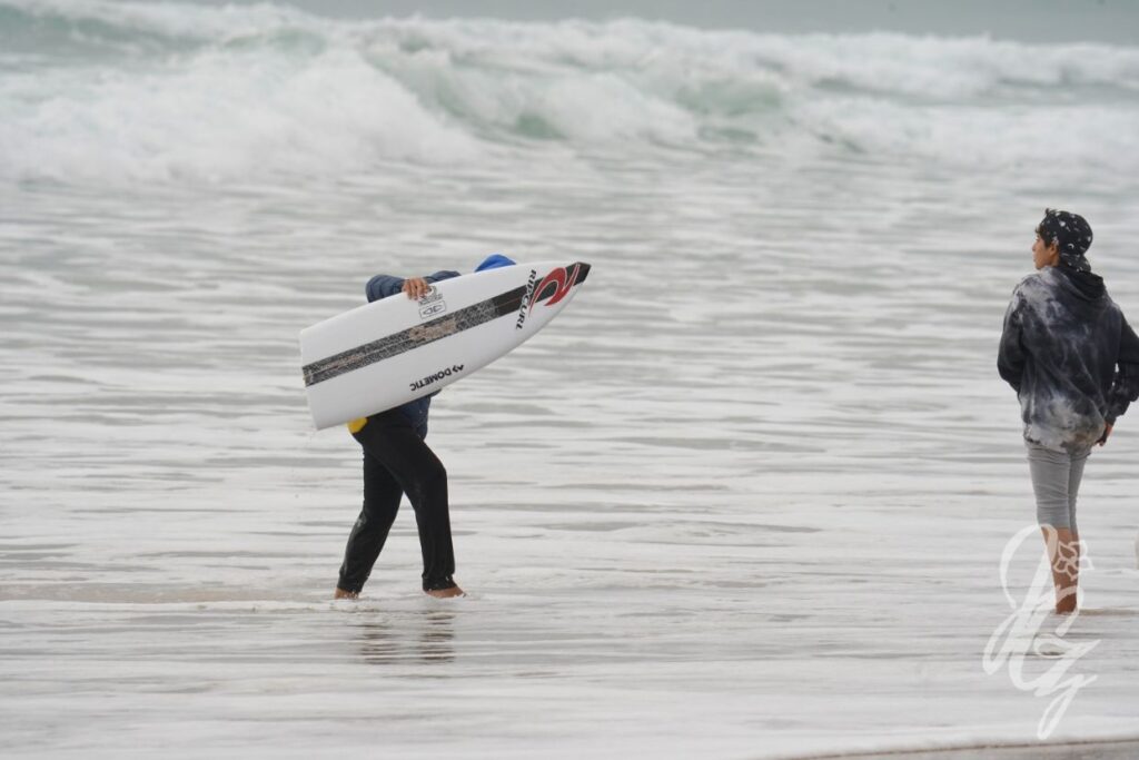 Boy carrying the broken board of Owen Writght at the Meo Pro Portugal 2022 at Supertubos in Peniche