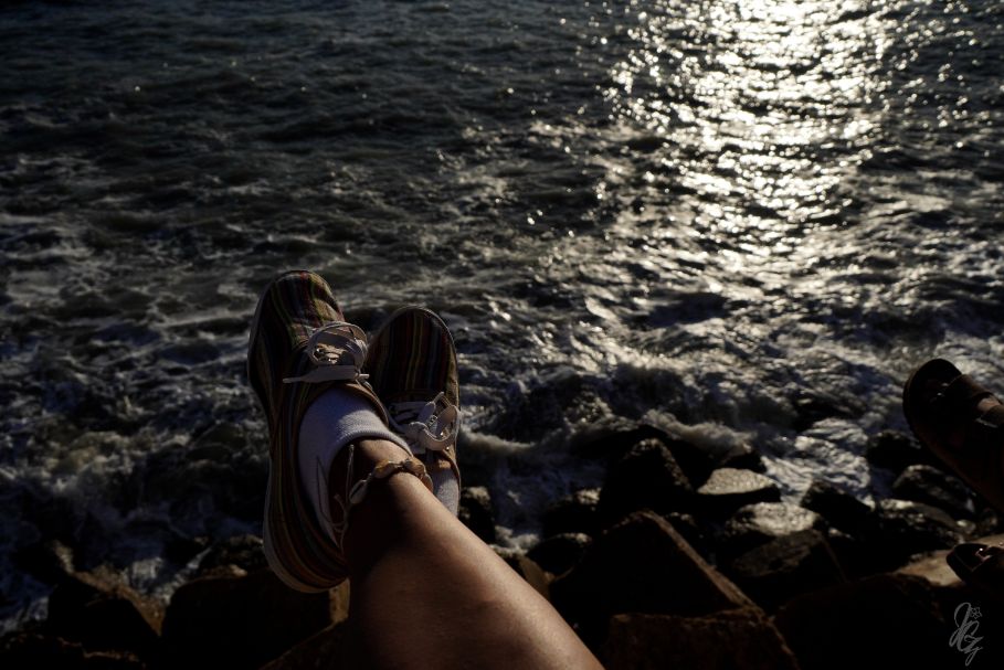 Legs stretched out over the sea