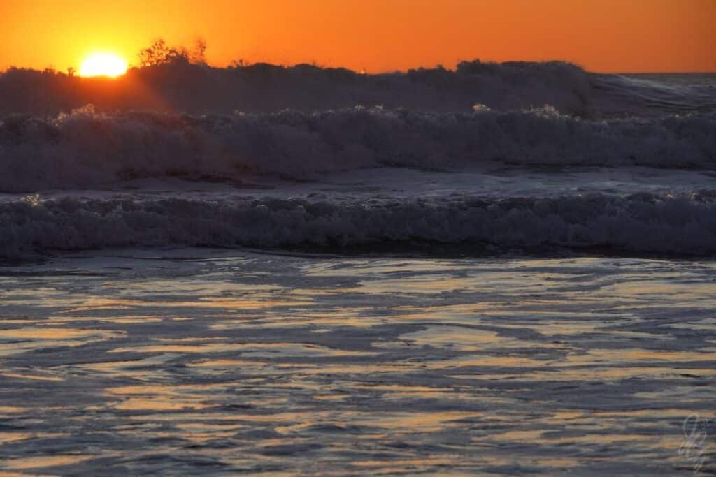 Sun setting behind the waves
