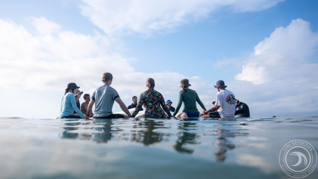 Surfers sitting in a circle after a paddle out