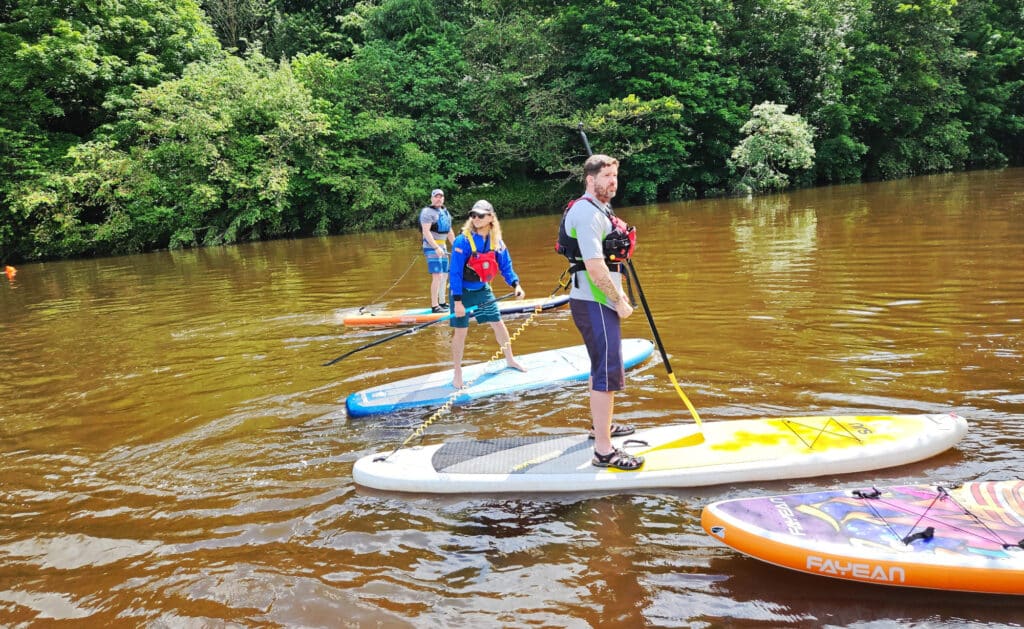 Paddleboarders on the river Eden during SUPfest