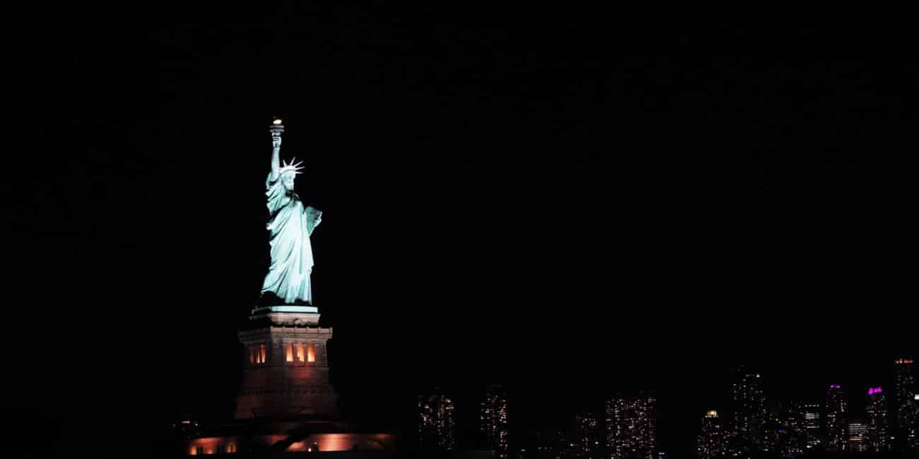 Statue of Liberty and New York skyline at night