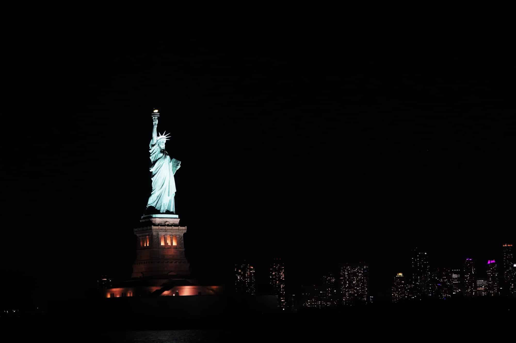 Statue of Liberty and New York skyline at night